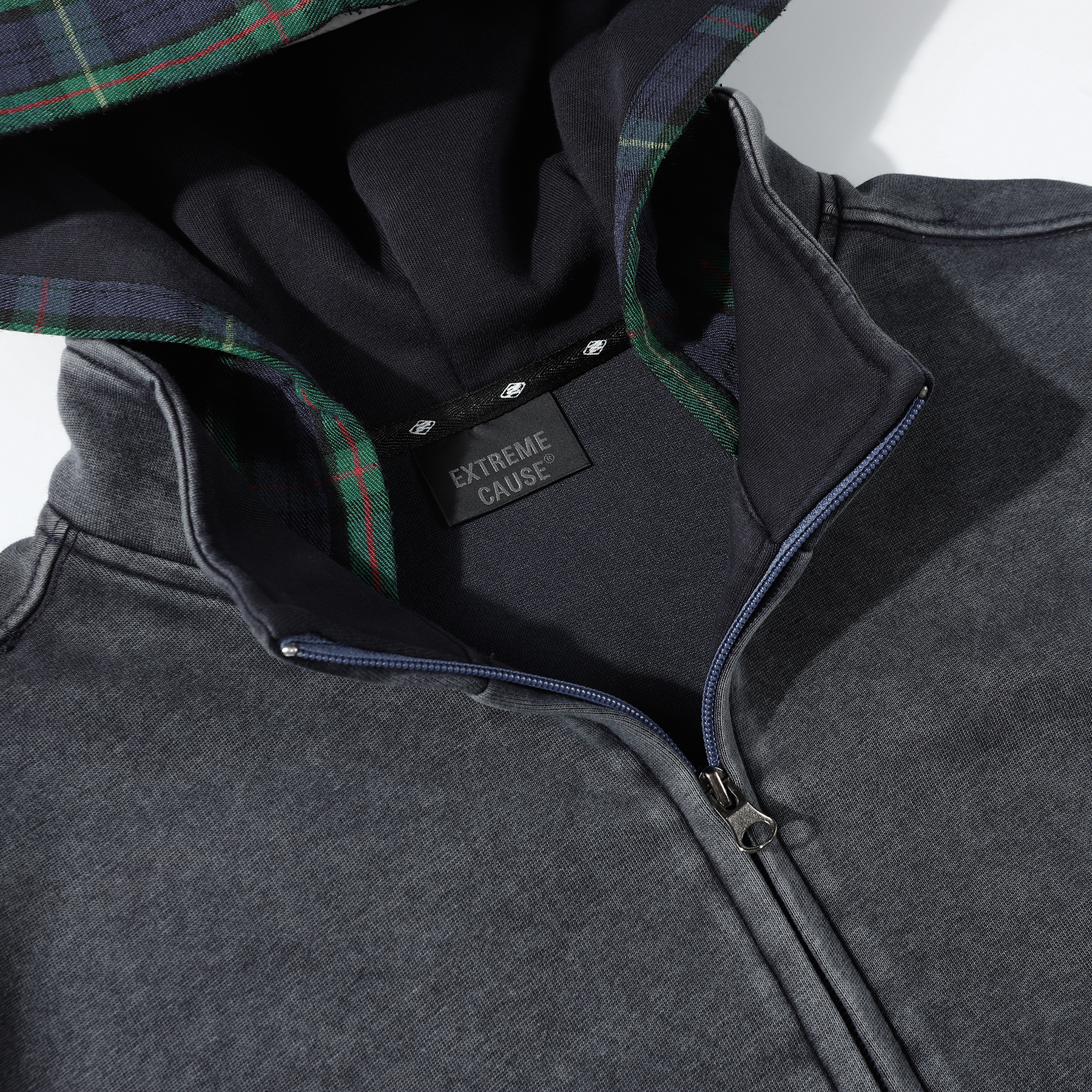 Close-up of dark gray vintage wash zip-up hoodie collar and zipper detail, heavyweight cotton custom apparel
