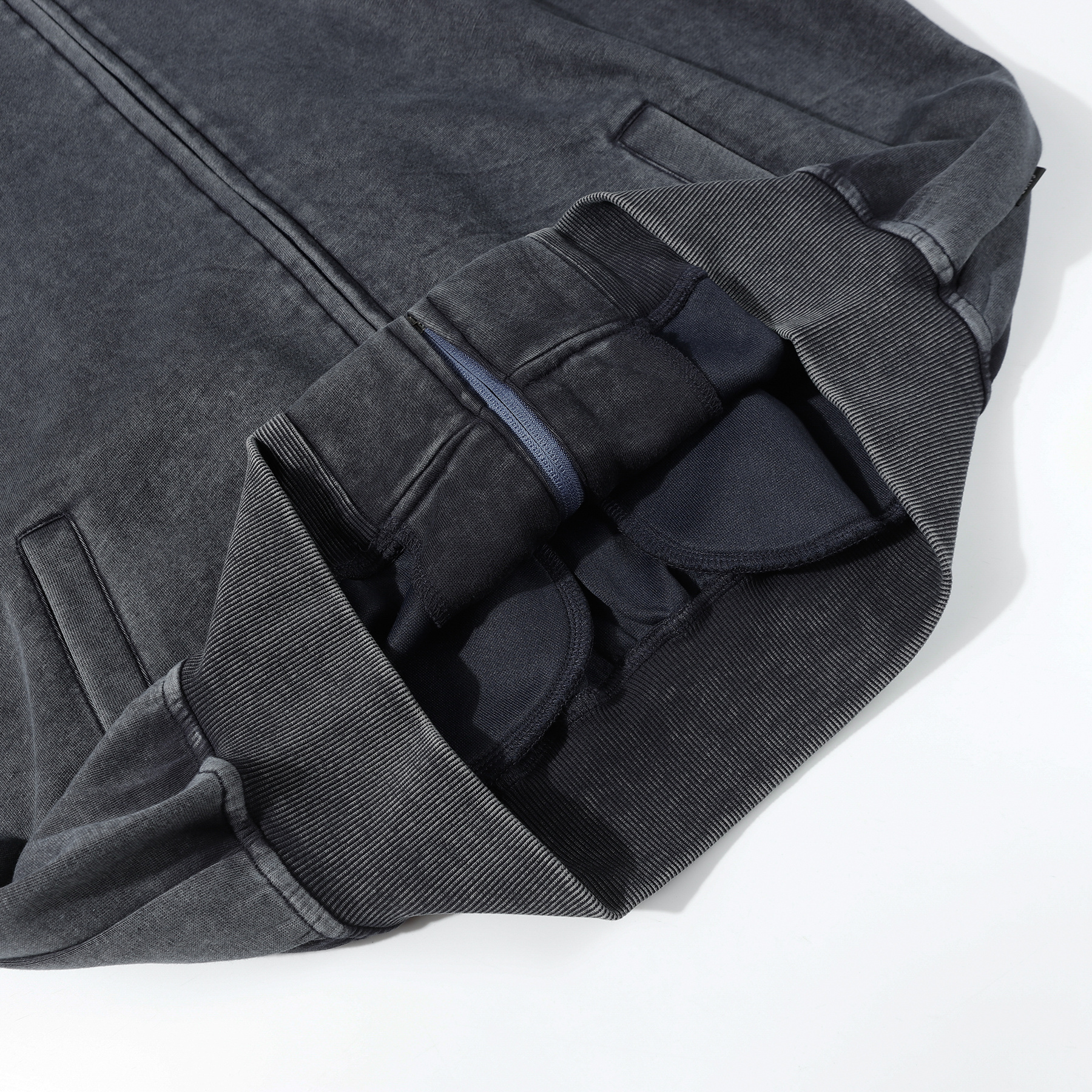 Close-up of dark gray vintage wash zip-up hoodie cuff and ribbed detail, heavyweight cotton custom apparel